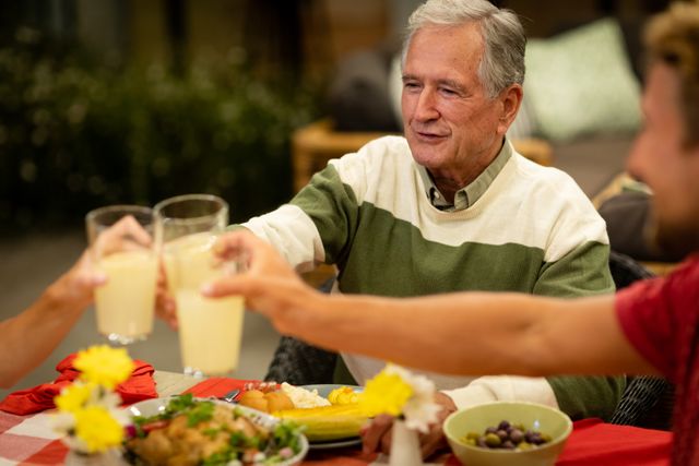 Multigenerational Family Toasting Lemonade at Dinner Table - Download Free Stock Photos Pikwizard.com