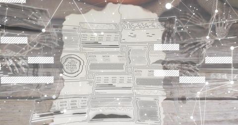 Hands in knit sleeves holding torn stamped document with digital network overlay on wooden table