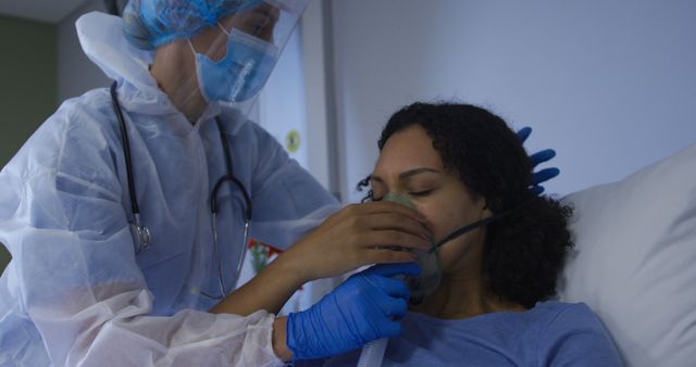 Healthcare worker assists a patient with an oxygen mask in a hospital setting, demonstrating medical support and care for patients requiring respiratory assistance. Ideal for use in health-related articles, medical websites, or educational materials about hospital care and nursing support.