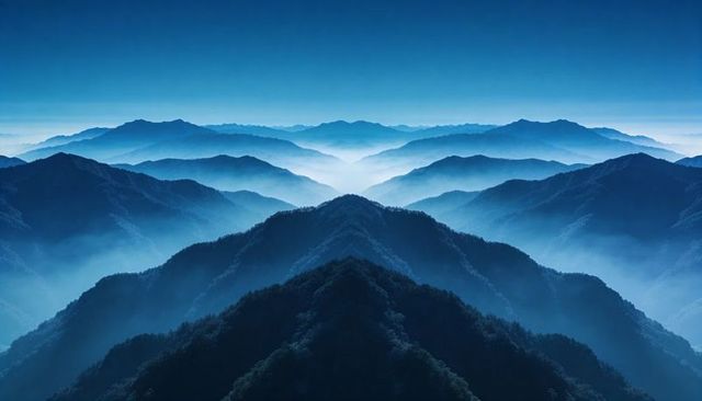 Revealing blue-mist mountain ridges stretching into layered foggy valleys, panoramic calm