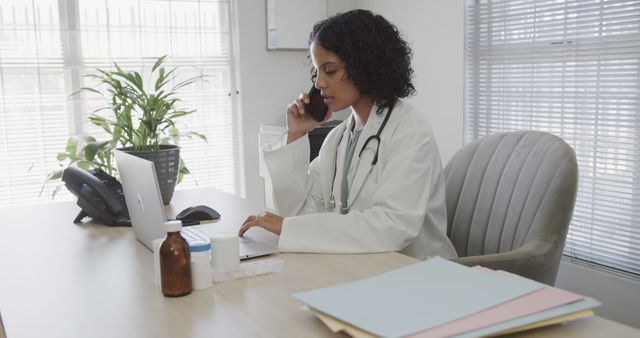 Female Doctor Talking on Phone While Working on Laptop in Office - Download Free Stock Images Pikwizard.com