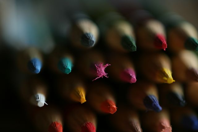 A detailed close-up of an array of colored pencil tips and muted background. Ideal for education materials, art supply advertising, or creative promotional content.