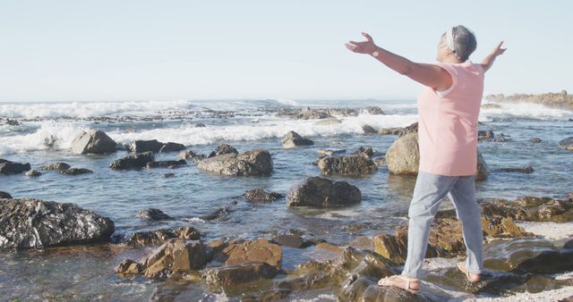 Senior Woman Embracing Nature at Rocky Shore in Casual Clothes - Download Free Stock Images Pikwizard.com