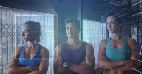Fitness trio standing with futuristic HUD overlay in urban industrial gym, teamwork energy