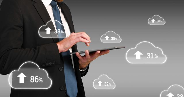 Composition of clouds with percent over businessman using tablet. Global cloud computing, business, networks, digital interface and data processing concept digitally generated image.
