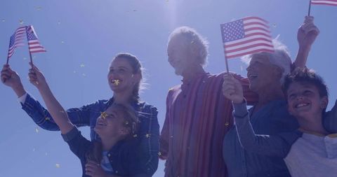 Family Celebrating with Flags and Gold Confetti Outdoors