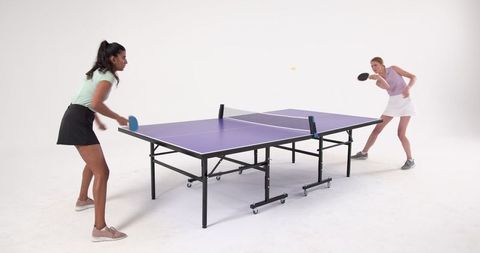 Diverse Women Enjoying Table Tennis in Minimalist Studio Sport Setting