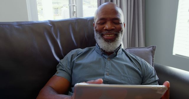 Senior Man Relaxing on Sofa Using Tablet and Smiling - Download Free Stock Photos Pikwizard.com