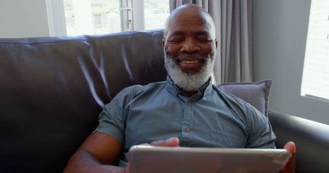 Senior Man Relaxing on Sofa Using Tablet and Smiling - Download Free Stock Images Pikwizard.com