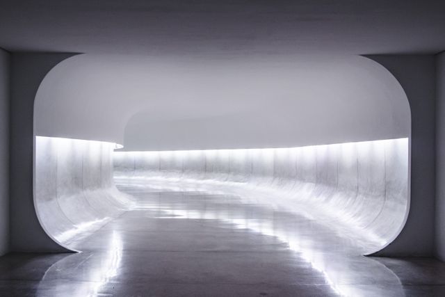 White curved hallway with sleek neon lighting forming smooth, continuous lines. Ideal for concepts of futurism, minimalism in design, clean architectural spaces, or innovative interior designs. Perfect for corporate backgrounds, technology ads, or modern living presentations.