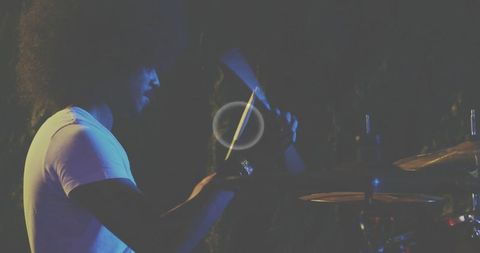Indian percussionist playing cabasa on stage at live concert