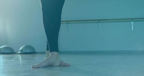 Ballet training barefoot on dance studio floor