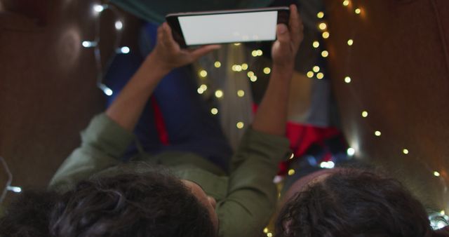 Friends Watching Tablet Inside Blanket Fort with String Lights - Download Free Stock Images Pikwizard.com