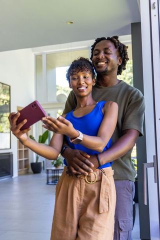 African american couple taking selfie in modern home entryway casual lifestyle moment