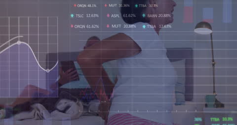 Overlay of Financial Data on Couple with Tablet