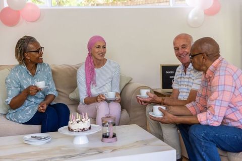 Diverse Friends Celebrating Cancer Survivor with Tea and Cake