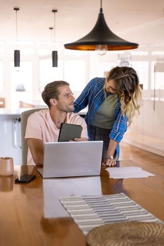 Couple Collaborating at Home on Project Using Digital Devices
