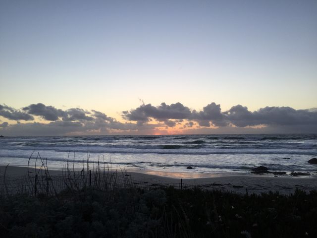 Peaceful Beach Sunset with Cloudy Sky Over Ocean Waves - Download Free Stock Photos Pikwizard.com