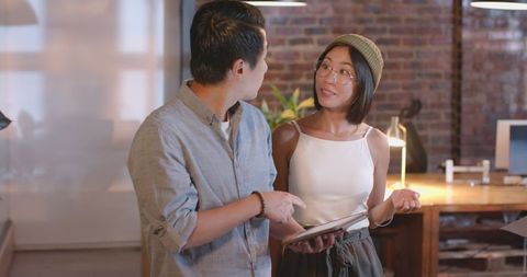 Asian Colleagues Collaborating on Digital Project in Modern Office