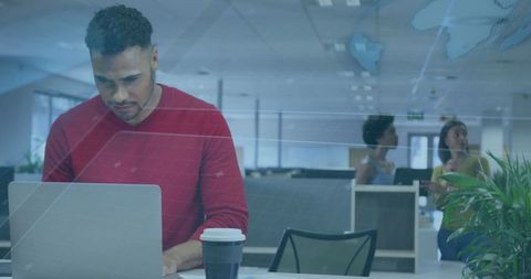 Focused Employee Working on Laptop in Modern Office Environment