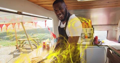 Smiling chef preparing delicious street food in vibrant food truck