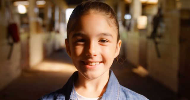 Smiling Girl Wearing Denim Jacket in Sunlit Barn - Download Free Stock Images Pikwizard.com