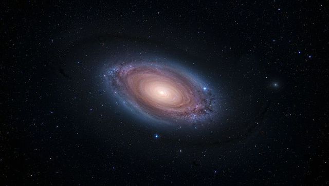 Swirling spiral galaxy revealing bright golden core, dust lanes and blue star clusters