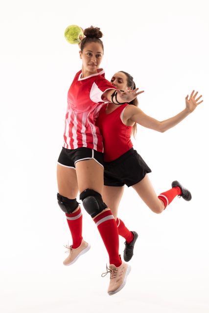 Confident female caucasian handball players competiting against white background. unaltered, sport, competition and game concept.