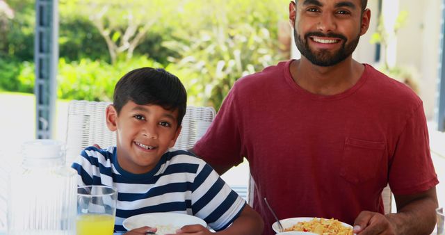 Smiling Father and Son Enjoying Breakfast Outdoors - Download Free Stock Images Pikwizard.com