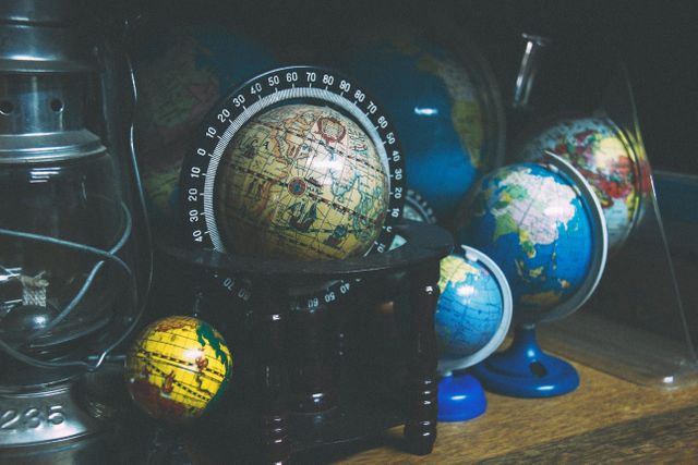 This image depicts an assortment of vintage globes, perfect for use in study rooms, libraries, or education-related content. The presence of different sized globes offers aesthetic appeal, making it suitable for articles or advertisements focusing on geography, education, vintage decor, or travel inspiration.