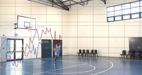 Basketball player dribbling across indoor court while digital performance graphs overlay
