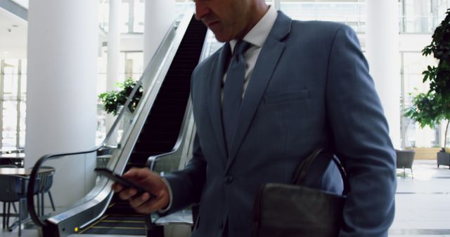 Businessman Using Smartphone in Modern Office Lobby - Download Free Stock Images Pikwizard.com