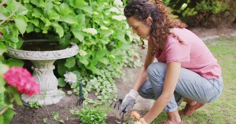 Woman Engaged in Gardening Focused on Plant Care Outdoors