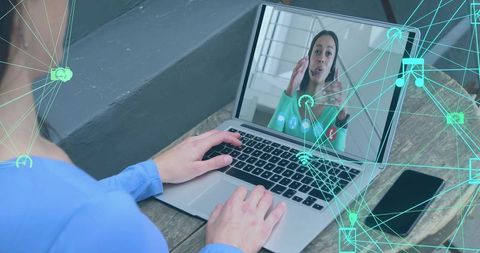 Typing during remote video call with woman speaking on laptop and teal network overlay