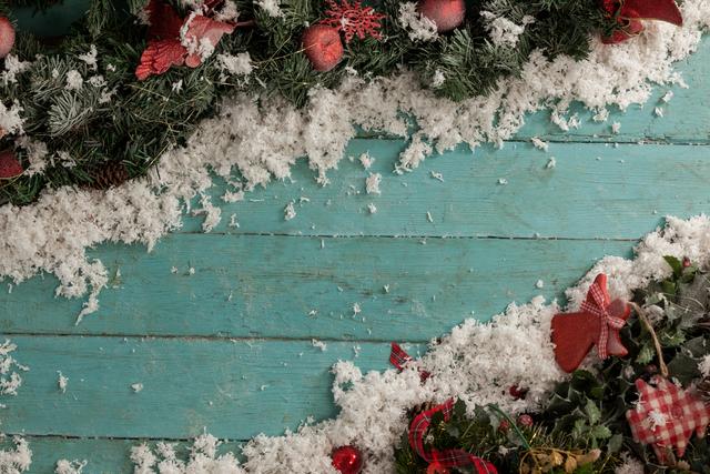 Christmas decorations with fake snow on a wooden plank. Ideal for holiday greeting cards, festive invitations, seasonal advertisements, and winter-themed social media posts.