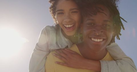 Joyful couple embrace in sunlit outdoor setting