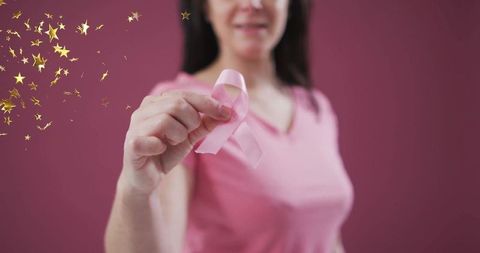 Woman Holding Pink Awareness Ribbon Against Pink Background
