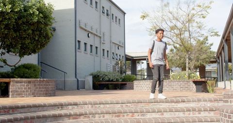 Teen with Backpack Taking Stand on School Brick Steps