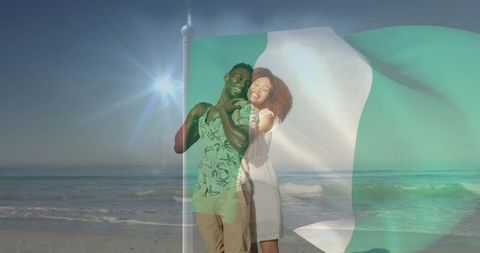 Romantic couple embracing on sunny beach through fluttering green white flag
