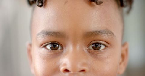 Close-up of Young Boy with Twisted Hairstyle and Expressive Eyes