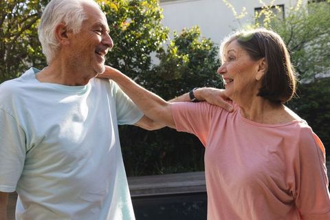 Senior Couple Laughing Together in Sunlit Garden