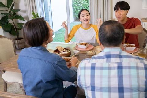 Happy Family Enjoying Meal Around Table at Home