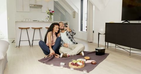 Couple Enjoying Indoor Picnic, Taking Selfie in Modern Living Room