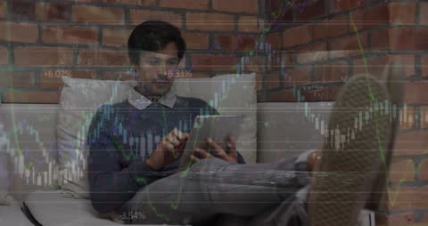 Young Man Analyzing Financial Data on Tablet at Home