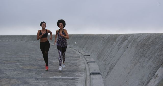 Two Women Jogging on Urban Seawall, Creating Fitness Goals - Download Free Stock Images Pikwizard.com