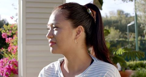 Smiling Woman with Ponytail Embracing Daylight Outdoors
