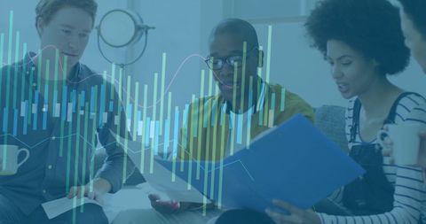 Colleagues from diverse backgrounds are seen evaluating financial charts and data in a professional setting. This representation of teamwork can be effectively used for marketing campaigns, business presentations, or illustrating financial and business articles highlighting collaboration, data analysis, and strategic planning processes.