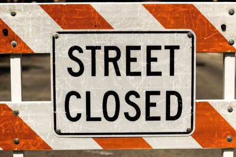 Street closed sign on barricade roadblock