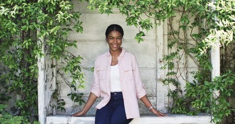 Young African American Woman Smiling in Leafy Alcove