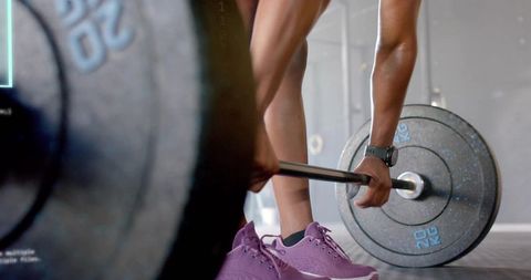 Female Athlete Preparing Deadlift with Loaded Barbell and Purple Sneakers